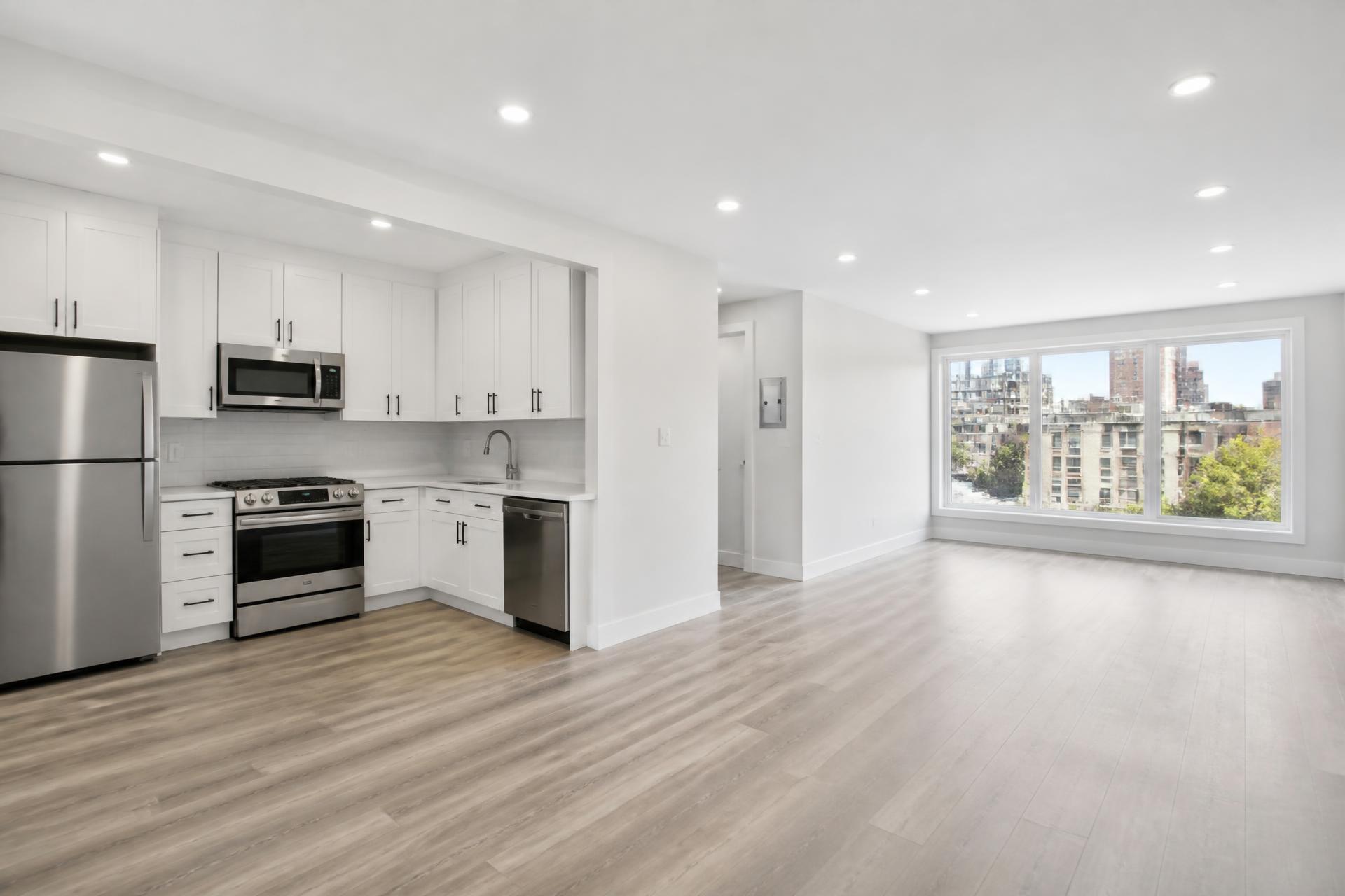 Newly renovated vacant apartment unit with white kitchen cabinets and vinyl plank flooring